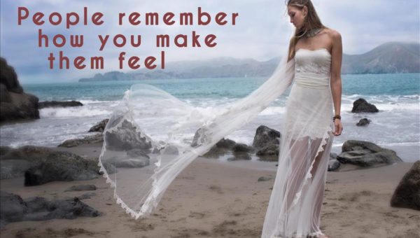Woman in windblown wedding dress on beach